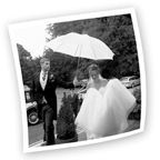 groom holding umbrella over bride